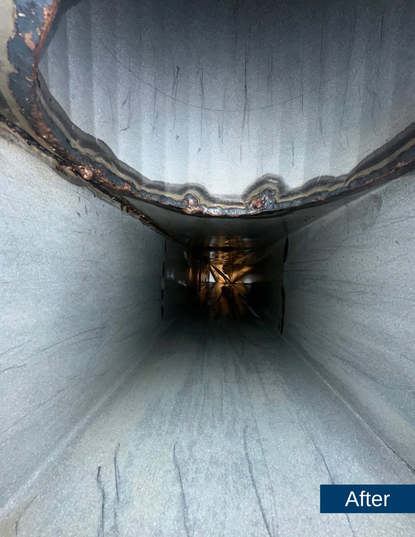 The same exhaust duct scraped to clean steel after service