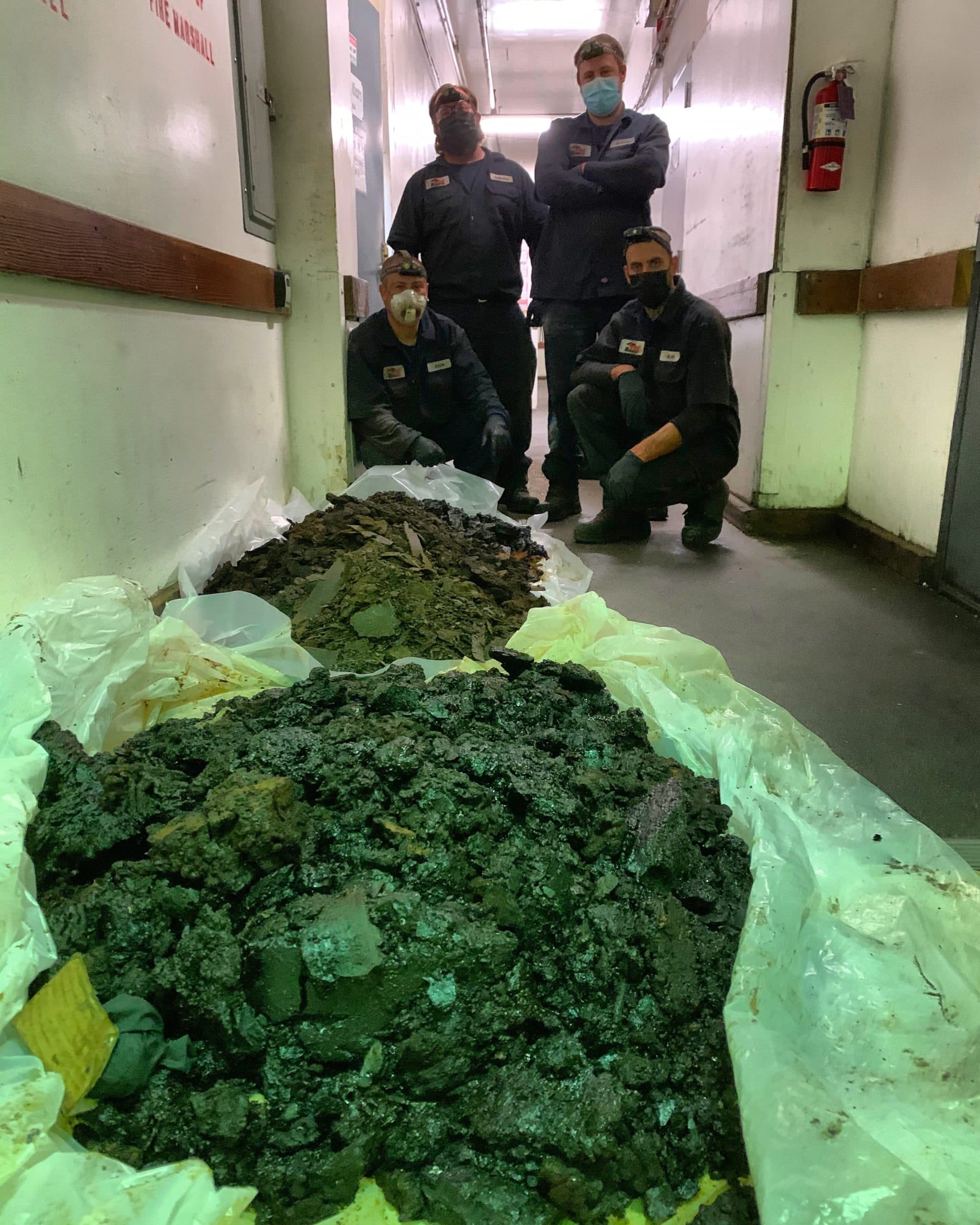 Bryan Exhaust crew posing with the grease removed from a commercial kitchen exhaust system