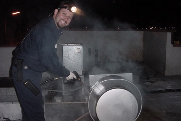 Technician Expertly Cleans Restaurant Kitchen Exhaust Fan