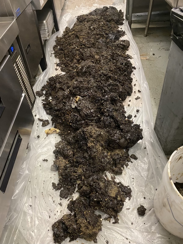 hood-cleaning-los-angeles-51 Grease buildup on plastic sheet in commercial kitchen, highlighting the importance of professional kitchen exhaust hood cleaning by Bryan Exhaust Service for safety and efficiency.