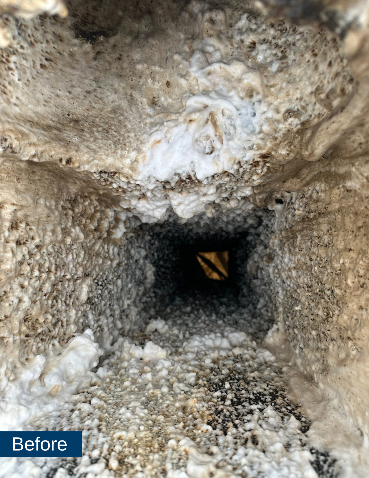 Close-up of a dirty kitchen exhaust duct showing thick grease and grime buildup, indicating the need for professional cleaning services by Bryan Exhaust Service.